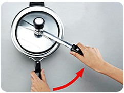 Step 2: swing the lid handle toward the body handle to begin releasing the lock